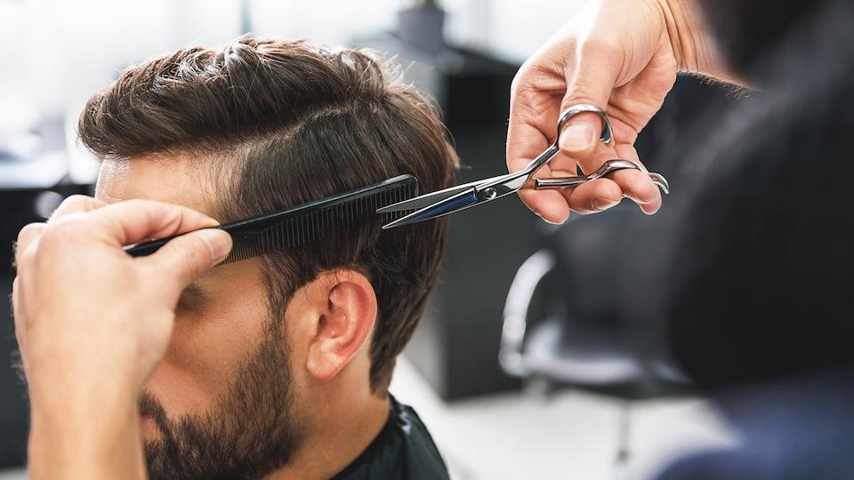 A hairdresser cutting a man's hair